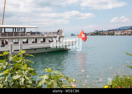 La Belle Epoque retro pédalo avec drapeau suisse à la poupe amarré à Montreux, lac Léman, Vaud, Suisse le jour d'été ensoleillé Banque D'Images