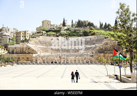 Un couple musulman détient les mains et marche à travers le parc en face de l'ancien amphithéâtre romain dans le centre de Amman Banque D'Images