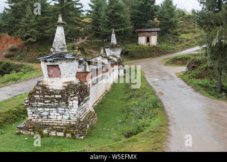 Un mur de prière bouddhiste et chorten ou stupa au bas de la route menant au monastère Gangtey dans la vallée de Phobjikha, Bhoutan Banque D'Images