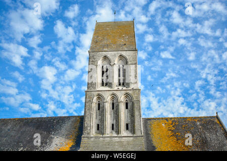 L'Eglise Saint-Martin à Formigny, Normandie, France, une église importante dans l'invasion du Jour J, montrant la tour, ciel bleu et les pigeons se percher. Banque D'Images