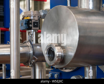 Cuve en acier inoxydable avec un regard en verre industriel à l'usine de traitement. Banque D'Images