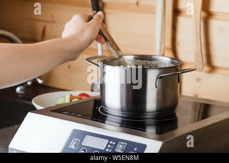 Soupe bouillante dans le moule sur une cuisinière électrique dans la cuisine Banque D'Images