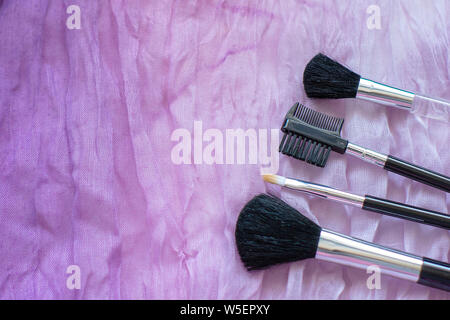 Maquillage professionnel libre sur l'arrière-plan de tissu ondulé froissé. Le concept de la beauté et de la mode. haut voir télévision lay. Copyspace. Banque D'Images