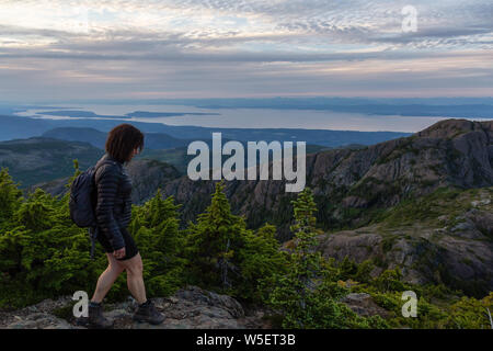 Fille d'aventure randonnées le beau sentier dans les paysages de montagne au cours de l'été animé d'un coucher du soleil. Prises au Mont Arrowsmith, près de Nanaimo, V Banque D'Images