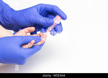 Le médecin prend le sang d'un doigt. Un test sanguin avec un scarificateur dans un enfant de valeurs et de soja d'érythrocytes, close-up, copy space, inflam Banque D'Images