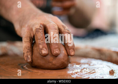 Les mains de potter. Le potter qui fait des plats de poterie sur tour de potier. Le sculpteur à l'atelier d'argile rend libre Banque D'Images