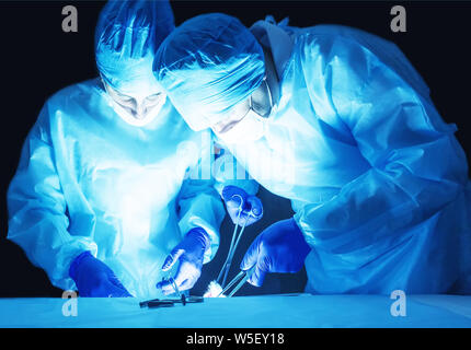 Deux chirurgiens, un homme et une femme, effectuer une chirurgie pour enlever adénome de prostate et, varicocèle, théâtre d'exploitation adénofibrome Banque D'Images
