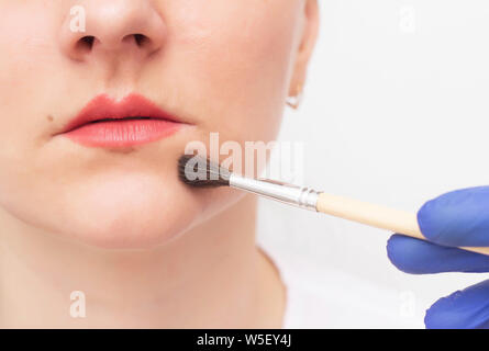 Cosmetologist médecin effectue des peeling chimique pour une fille d'augmenter des lèvres, tatouage, medicine Banque D'Images