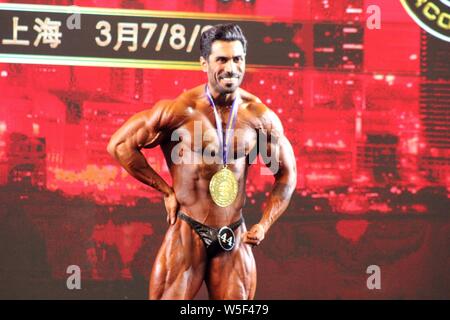 Un bodybuilder iranien pose après avoir gagné au cours de la 'Coupe Tera NABBA/WFF' Pro-am Carnaval de culturisme de Shanghai à Shanghai, Chine, le 7 mars 2019. T Banque D'Images