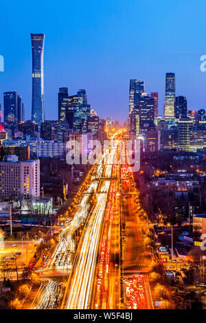 Une vue de la nuit de la routes très fréquentées avec des masses de véhicules en face de la tour et d'autres gratte-ciel CITIC dans le CBD (Central Business District) à Bei Banque D'Images