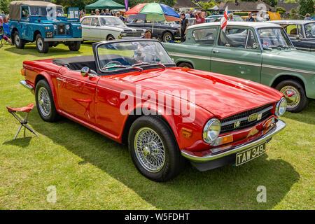 Vue latérale d'un vintage Triumph TR6, en voiture de sport rouge brillant, à l'affiche au salon de voitures annuel dans Wroxham, Norfolk, UK Banque D'Images