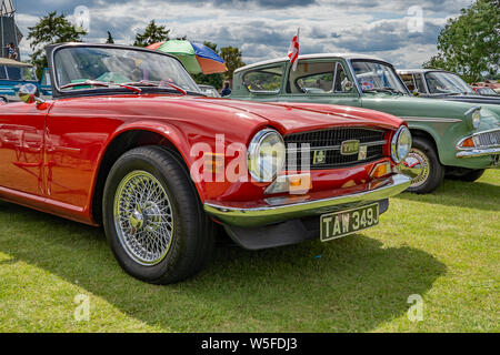 Vue frontale d'un vintage Triumph TR6, en voiture de sport rouge brillant, à l'affiche au salon de voitures annuel dans Wroxham, Norfolk, UK Banque D'Images