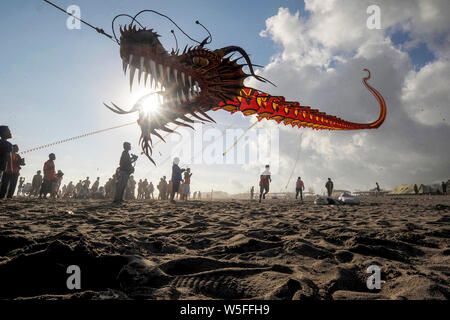 (190729) -- BEIJING, 29 juillet 2019 (Xinhua) -- Les participants voler leurs cerfs-volants dragon lors de la 7ème Festival International de Cerf-volant Jogja annuelle 2019 tenue à Parangkusumo beach à Yogyakarta, Indonésie, le 28 juillet 2019. (Photo par Supriyanto/2 Hua Qiang) Banque D'Images