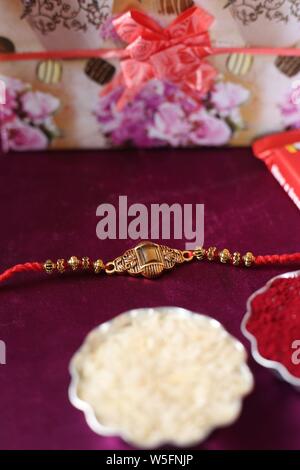 Festival indien : Raksha Bandhan arrière-plan avec un élégant Rakhi, grains de riz et de kumkum. Un bracelet traditionnel indien qui est un symbole de l'amour. Banque D'Images