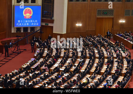 Adjoints suivent la troisième séance plénière de la deuxième session de la 13e Assemblée populaire nationale (APN) dans le Grand Hall du Peuple de Pékin en Banque D'Images