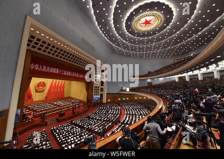 Adjoints suivent la troisième séance plénière de la deuxième session de la 13e Assemblée populaire nationale (APN) dans le Grand Hall du Peuple de Pékin en Banque D'Images