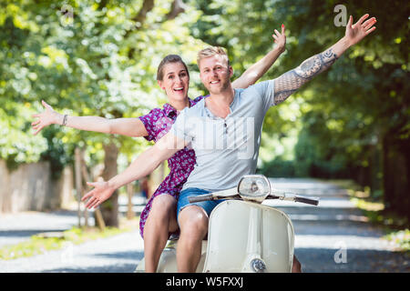 Jeune couple sur scooter rétro Banque D'Images