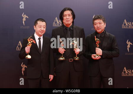 (De gauche) réalisateur chinois Jia Zhangke, réalisateur sud-coréen Lee Chang-dong, et le réalisateur japonais Hirokazu KORE-EDA posent avec leur trop Banque D'Images