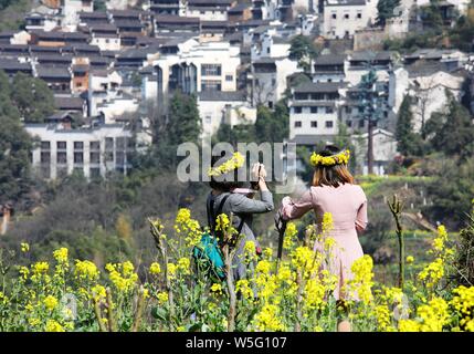 Des touristes posent pour des photos avec les fleurs de colza en pleine floraison dans l'ancien village de Huangling comté de Wuyuan Shangrao, ville, à l'est Chi Banque D'Images