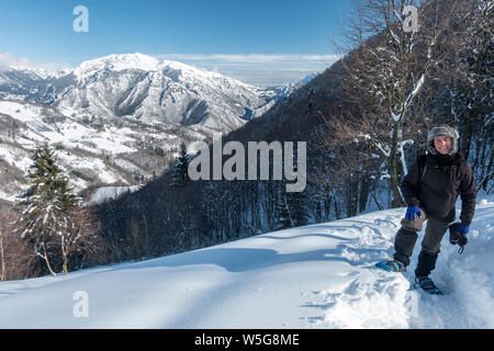 L'Italie, Lombardie, Alpes Orobie Regional Park, la raquette sur la piste vers Grialeggio Pass : Vallée Brembana et Mt. Menna couverte de neige Banque D'Images