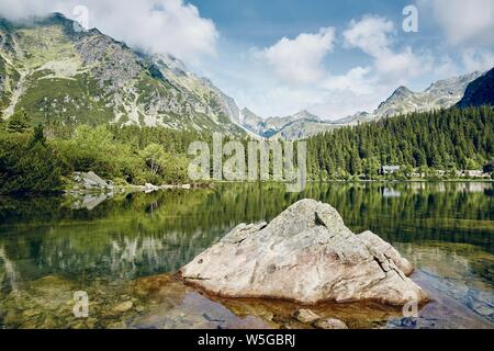 Magnifique lac contre des montagnes rocheuses. Popradske pleso dans les Hautes Tatras, en Slovaquie. Banque D'Images