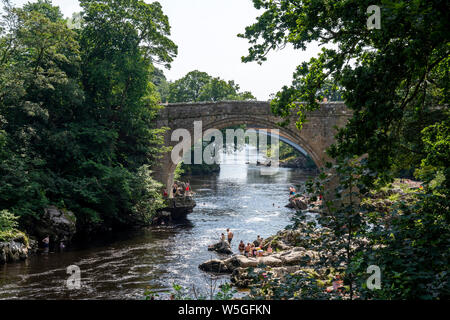 Journée la plus chaude de l'année 25 juillet 2019. Vue du Devils Bridge, avec la rivière Lune, Kirkby Lonsdale, les familles se rafraîchir dans la rivière. Kirkby Lonsda Banque D'Images