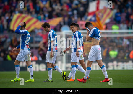 Wu Lei, deuxième à droite, et des membres de l'équipe de l'Espanyol à pied hors du terrain après qu'ils ont été battus par le FC Barcelone durant leur 29e match de la L Banque D'Images