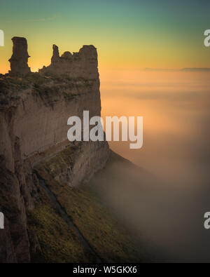 Magnifique photo aérienne de roches hautes du désert avec des parties inférieures couvert de brume et de nuages au coucher du soleil Banque D'Images