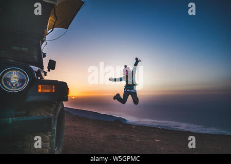 Billet d'habitudes de vie et la recherche du bonheur pour les personnes - femme de retour de saut et jouissant de la liberté et de beaux coucher de soleil à la montagne - voiture avec Banque D'Images