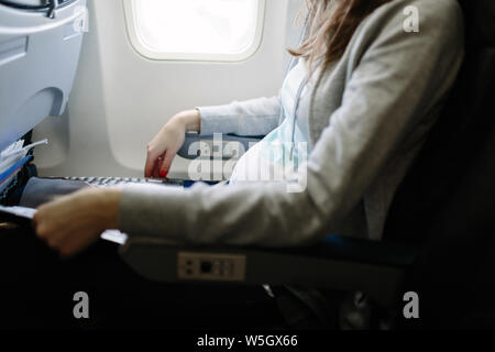 Femme enceinte qui voyagent en avion. Air travel concept Banque D'Images