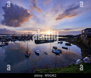 Lever du soleil de printemps à l'autre côté du port le port de pêche de Newlyn, Cornwall, Angleterre, Royaume-Uni, Europe Banque D'Images