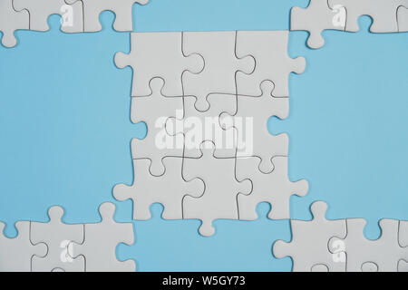 Jigsaw Puzzle pieces manquantes. Concept d'entreprise. Fragment d'un puzzle blanc plié et un tas d'éléments de puzzle non peignées contre l'arrière-plan Banque D'Images