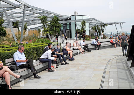 Les gens à l'heure du déjeuner assis sur des bancs mangeant le déjeuner sur la terrasse au jardin au 120 sur Fenchurch Street en juillet dans la ville de Londres UK KATHY DEWITT Banque D'Images