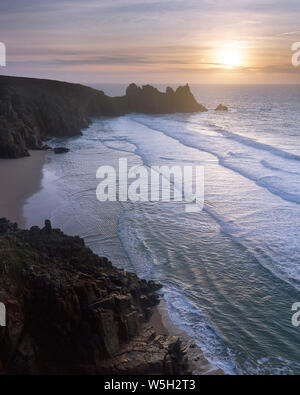 Le lever du soleil sur la belle plage isolée et Vounder au Pedn surplombant Logan Rock, près de Porthcurno, Cornwall, Angleterre, Royaume-Uni, Europe Banque D'Images