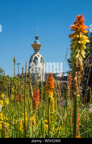 Tour Lu à Nantes sur une journée ensoleillée avec de la végétation verte et orange Fleurs Lilly flambeau commun Banque D'Images