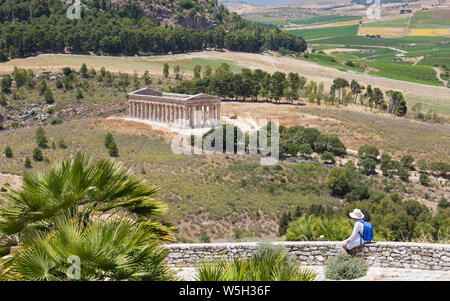 Visiteur admirant vue sur le magnifique temple dorique à l'ancienne ville grecque de Calatafimi Segesta, Erice, Sicile, Italie, Méditerranée, Banque D'Images