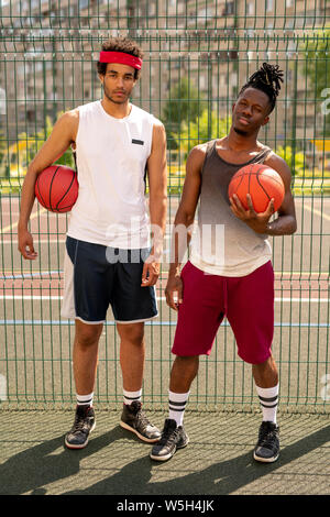 Deux jeunes joueurs de basket-ball multiculturel professionnel sur aire Banque D'Images