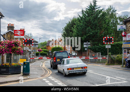 Voitures attendre à un passage à niveau à la gare de Datchet que les barrières ne sont pas et les feux d'avertissement clignotent comme un train qui passe est imminente. Banque D'Images