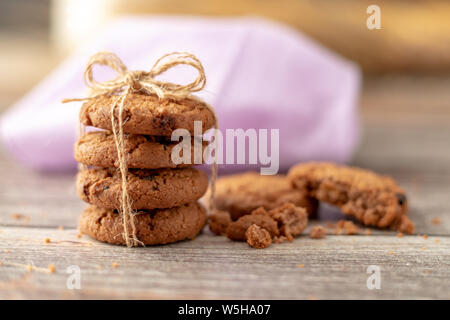 Utilisation de cookies empilés sur une corde d'une table en bois et d'une pièce cassée. Banque D'Images