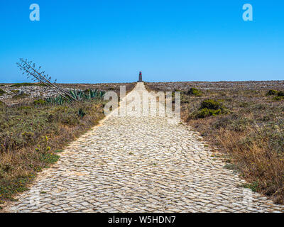 Le chemin de pierre menant au phare de Ponta de Sagres à l'intérieur de la zone de protection spéciale de la Forteresse de Sagres. Banque D'Images