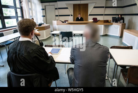 29 juillet 2019, Berlin : un agent de police de Berlin (r) est assis à côté de son avocat dans une salle du tribunal de district avant le début du procès. Le 51-year-old a à répondre devant les tribunaux pour possession illégale de deux anneaux de céder. Selon le ministère public, la même personne est soupçonnée de conduite d'un homme âgé de 21 ans tandis que la voiture sous l'influence de l'alcool au volant d'une voiture de patrouille, il y a un an et demi, ce qui a blessé mortellement sa. Dans ce cas, les enquêtes sont plus attendus. Photo : Paul Zinken/DPA - ATTENTION : La personne était pixelisées pour des raisons juridiques par ordre de la l Banque D'Images
