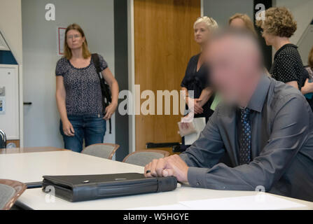 29 juillet 2019, Berlin : un policier de Berlin est assis dans une pièce du Tribunal de district avant le début du procès. Le 51-year-old a à répondre devant les tribunaux pour possession illégale de deux anneaux de céder. Selon le ministère public, la même personne est soupçonnée de conduite d'un homme âgé de 21 ans tandis que la voiture sous l'influence de l'alcool au volant d'une voiture de patrouille, il y a un an et demi, ce qui a blessé mortellement sa. Dans ce cas, les enquêtes sont plus attendus. Photo : Paul Zinken/DPA - ATTENTION : La personne était pixelisées pour des raisons juridiques par ordre de l'avocat Banque D'Images