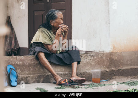 Luang Prabang, Laos - Mai 2019 : vieille femme Lao est assis sur le porche de la chambre, pensif. Banque D'Images
