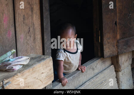 Sapa, Vietnam - Mai 2019 : petit enfant vietnamien donnant sur véranda en bois Banque D'Images