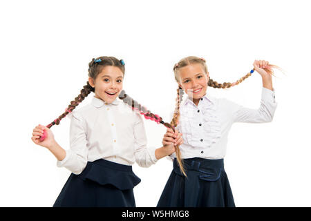 Aider les cheveux pousser plus vite. Adorables petits enfants prendre soin de cheveux longs. Petit mignon girl holding longs cheveux tresses, isolé sur blanc. Porter les cheveux longs en tresses pour l'école. Banque D'Images