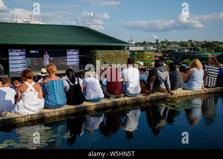 Fans et spectateurs sur Henman Hill , Murray Mound ou Aorangi Hill avec le grand écran sur la Cour n° 1 durant les championnats de Wimbledon 2019. Banque D'Images