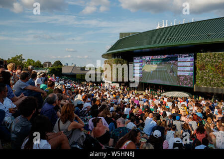 Fans et spectateurs sur Henman Hill , Murray Mound ou Aorangi Hill avec le grand écran sur la Cour n° 1 durant les championnats de Wimbledon 2019. Banque D'Images