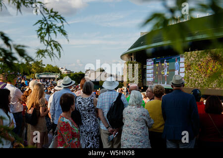 Fans et spectateurs sur Henman Hill , Murray Mound ou Aorangi Hill avec le grand écran sur la Cour n° 1 durant les championnats de Wimbledon 2019. Banque D'Images