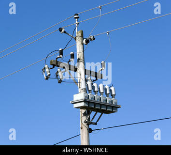 Point de connexion de la ligne de transport électrique sur perche avec transformateurs isolants et les fusibles. Banque D'Images