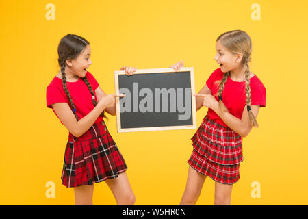 Cours de Cheerleading. Équipe de l'initiative de camarades. Inscrivez-vous le club scolaire. Les élèves de la communauté. L'annexe de l'école. School girls cute pupils uniforme rouge tenir copie tableau noir l'espace. Annonce école concept. Banque D'Images